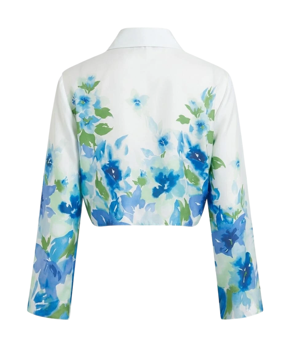 Back view of Mkeyzee London Fiorella cropped cotton shirt in white with a blue floral print and bracelet sleeves.